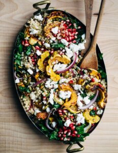 A serving dish with a colorful couscous salad