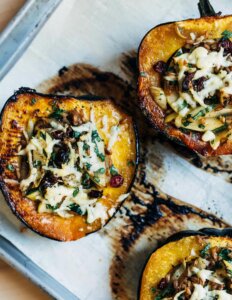 Stuffed acorn squash on a baking sheet.