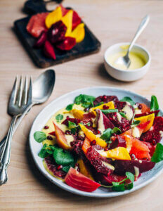 A shallow bowl filled with a beet and blood orange salad.
