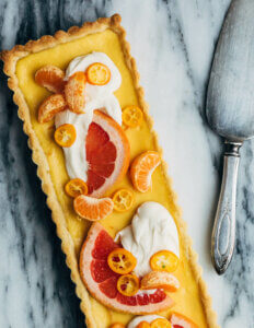 A rectangular tart eith citrus curd and sliced citrus.