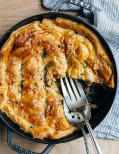 A cast iron skillet filled with a mushroom and leek chicken pot pie