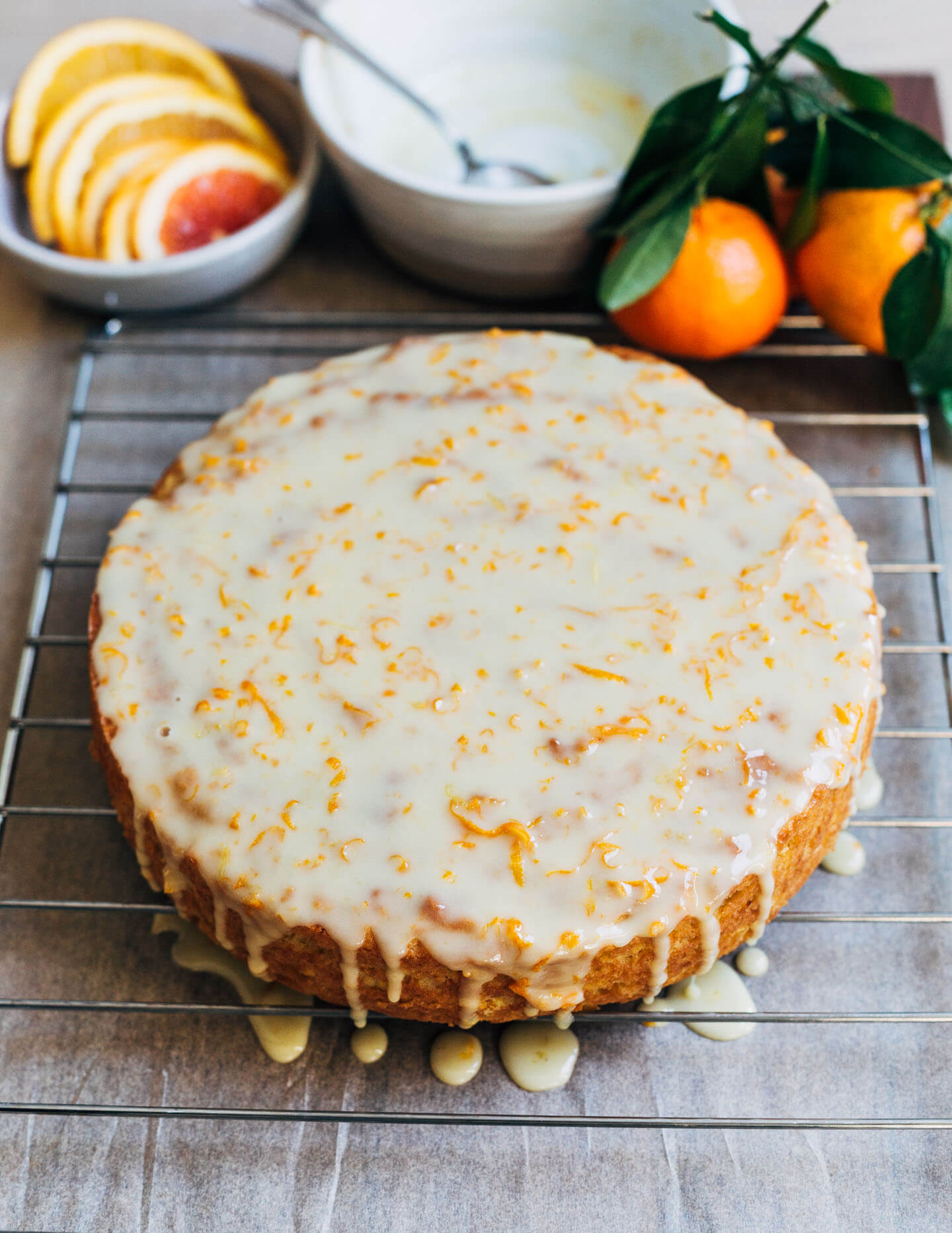 A cake on a rack with glaze dripping down. 