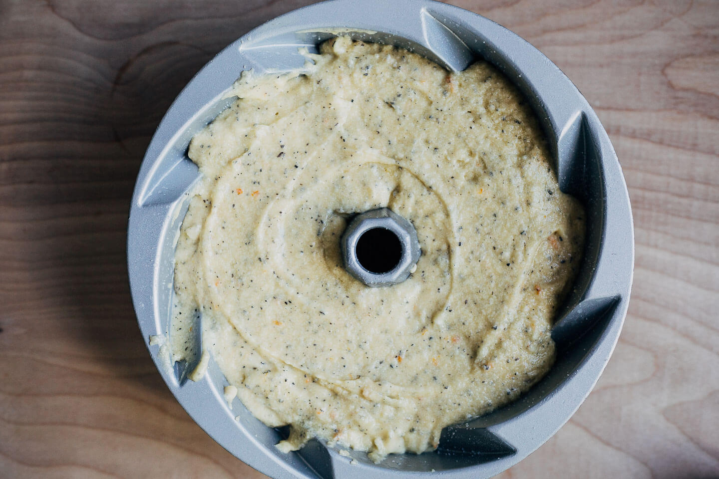 A bundt pan filled with batter and ready to bake.
