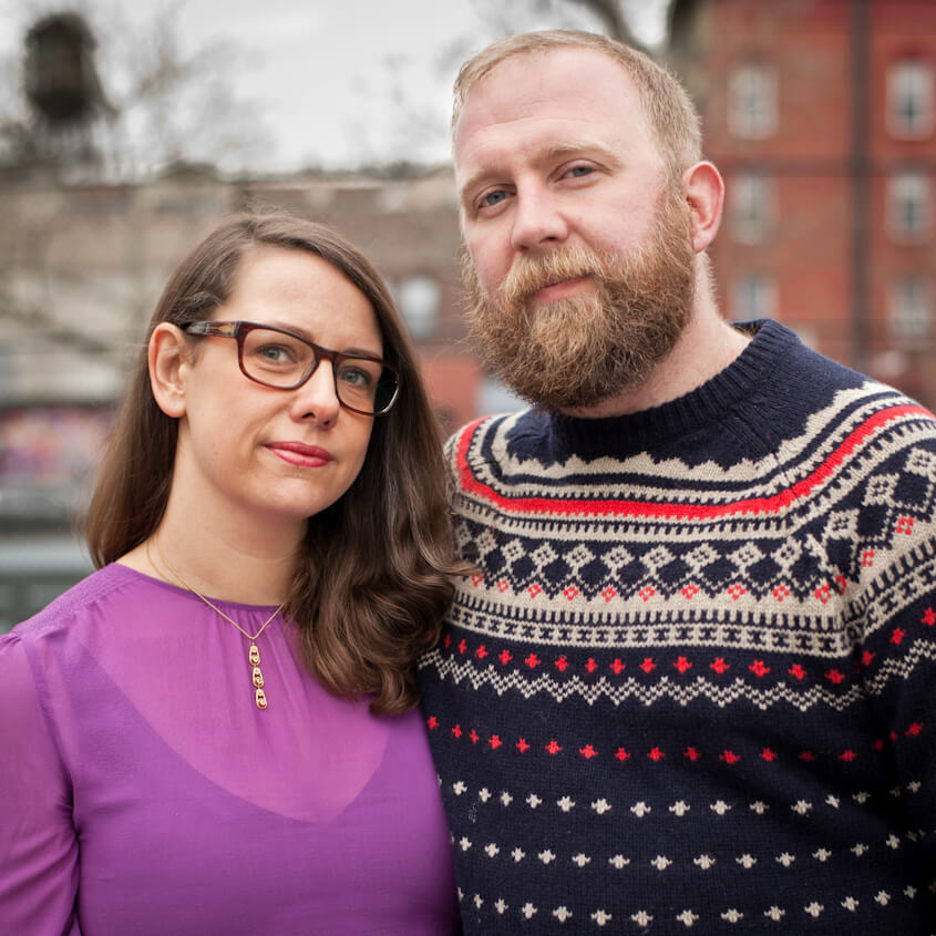 A woman with glasses and brown hair standing next to a blond man with a beard. 
