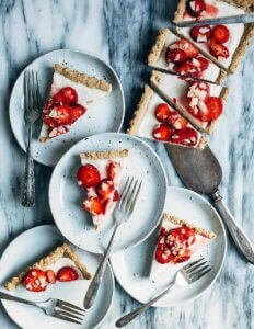 A rectangular tart with several slices served on little plates.