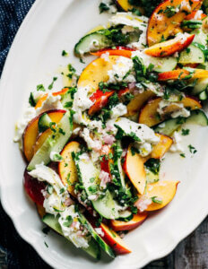 A platter with a cucumber, nectarine, and burrata salad.