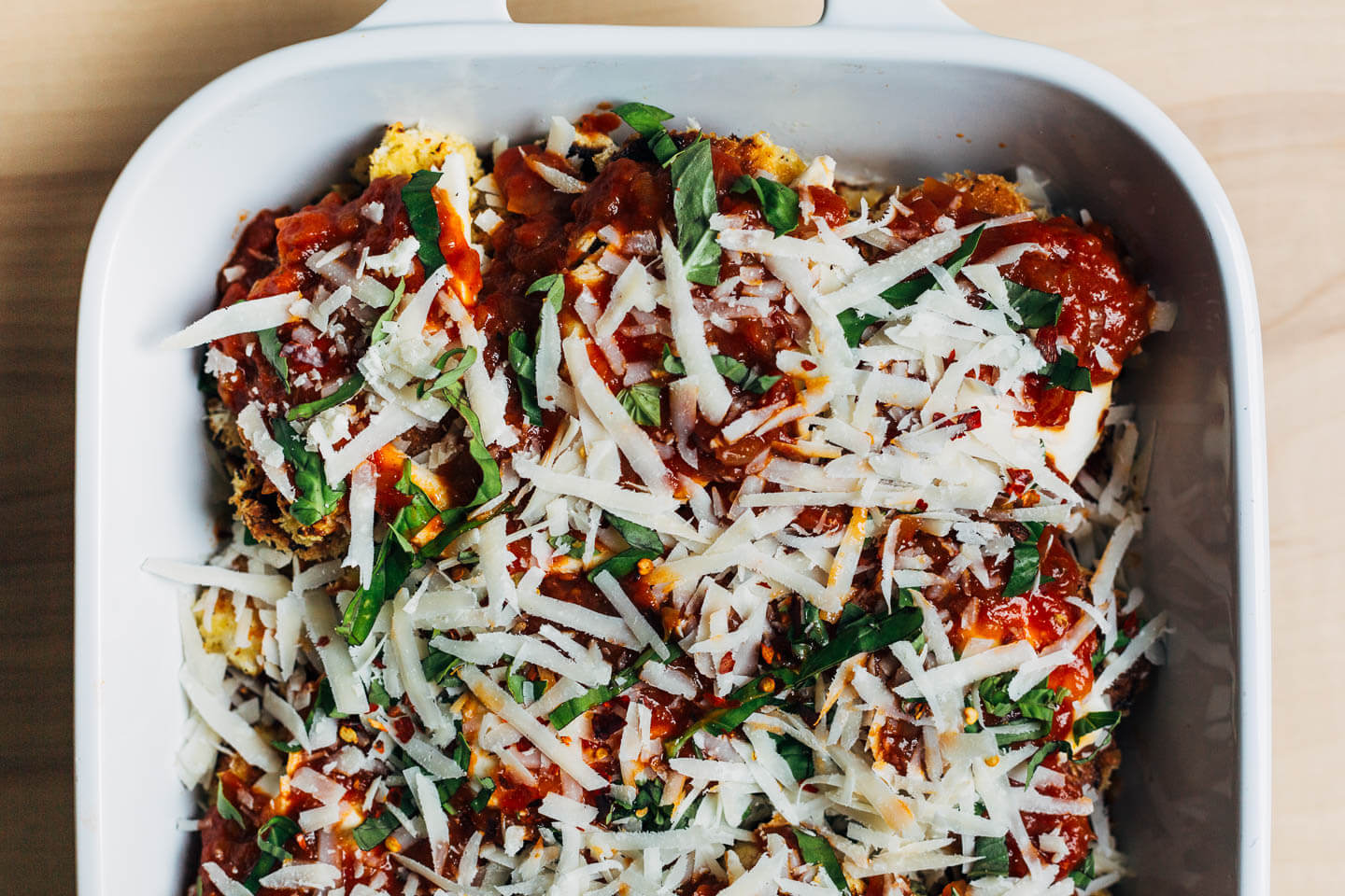 A baking dish with cauliflower Parmesan, assembled and ready to bake. 