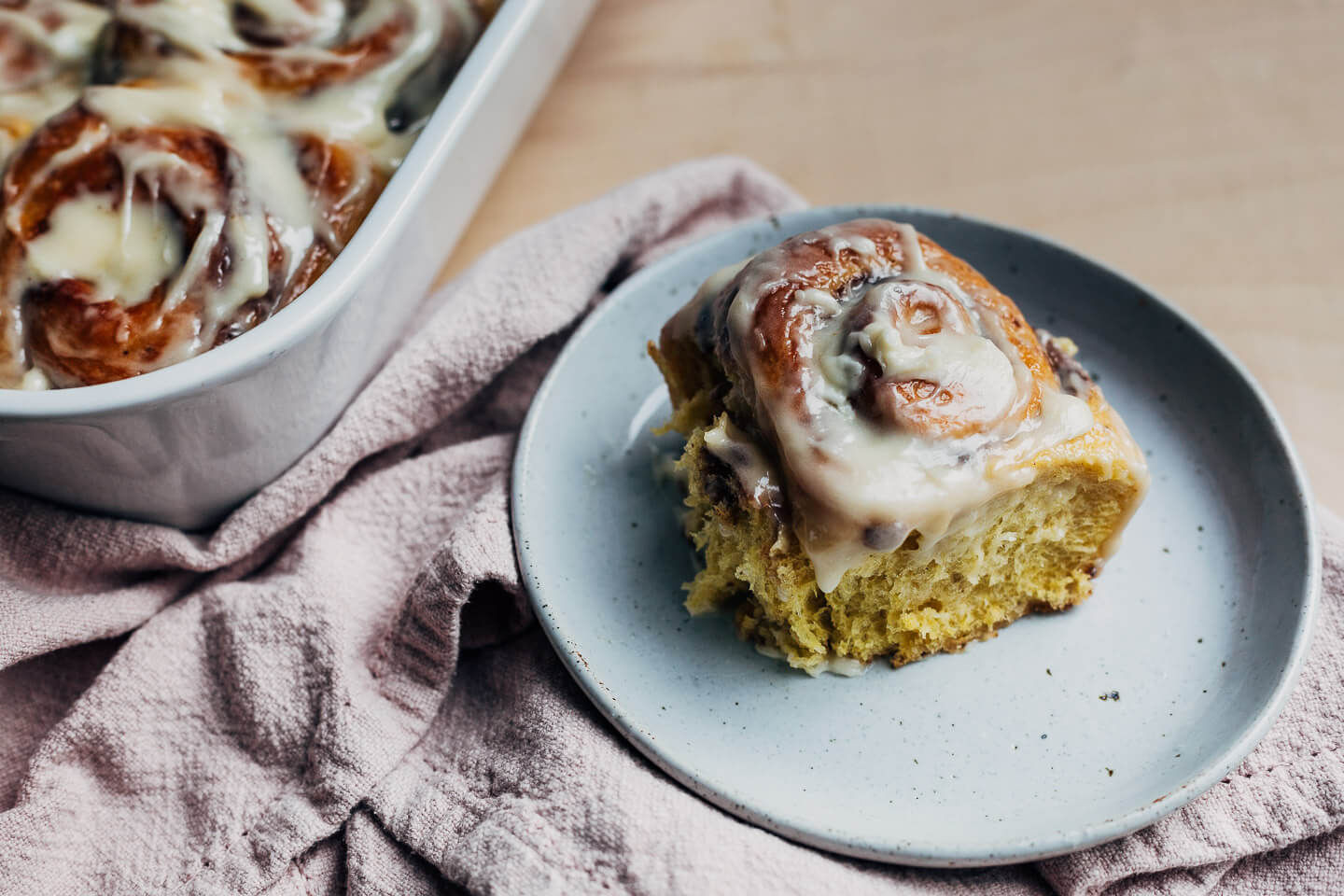 A pumpkin cinnamon roll on a plate. 