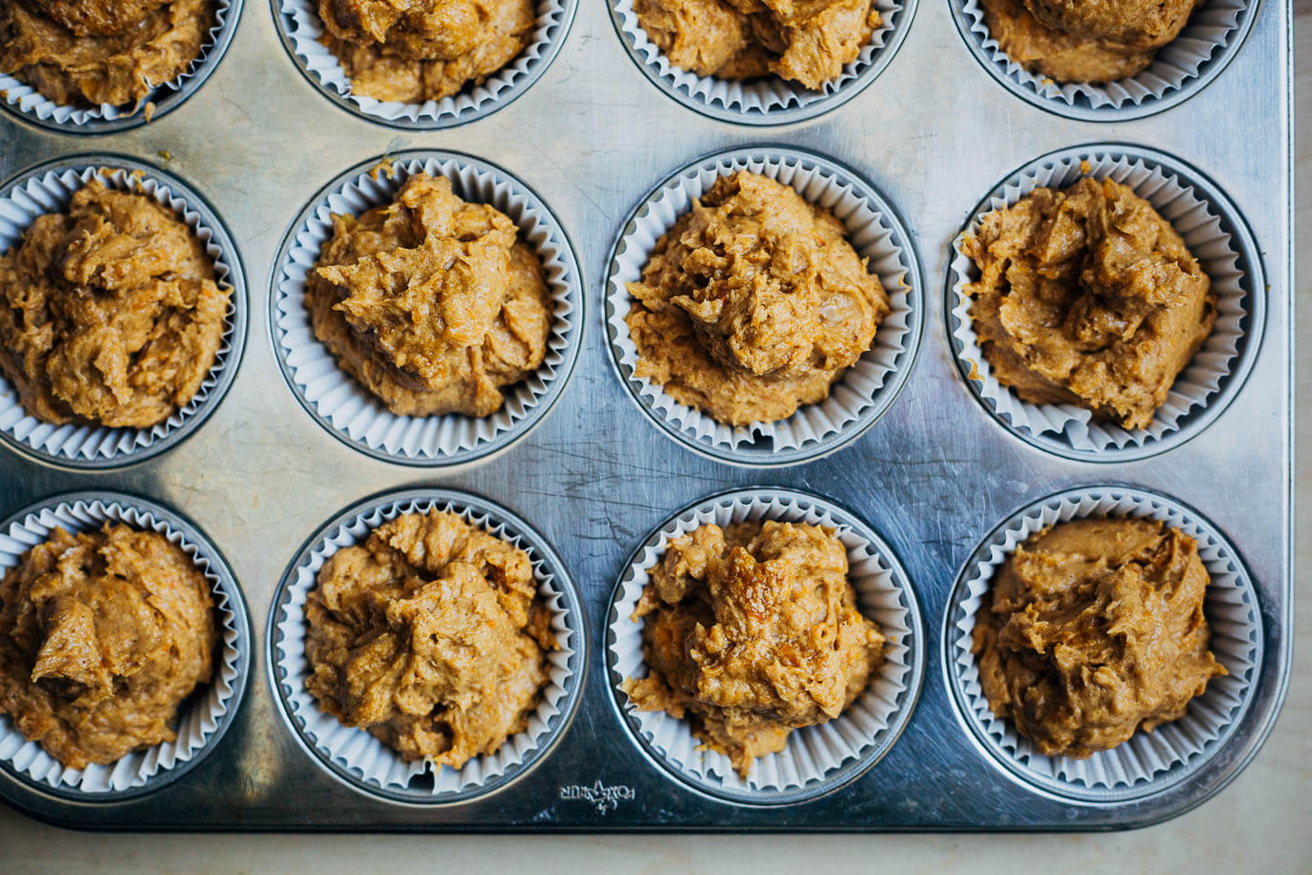 Batter in a muffin tin, ready to bake. 