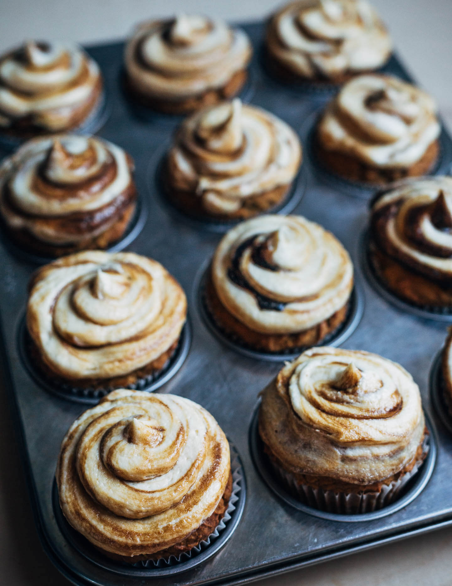 Frosted cupcakes in a muffin tin. 