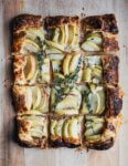 A sliced apple tart on a cutting board.
