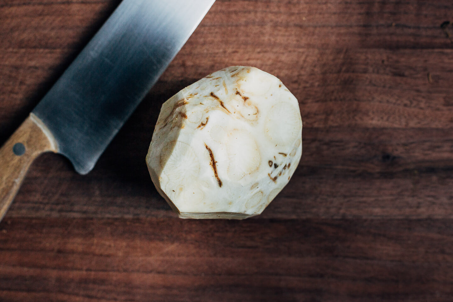 A trimmed celery root on a cutting board