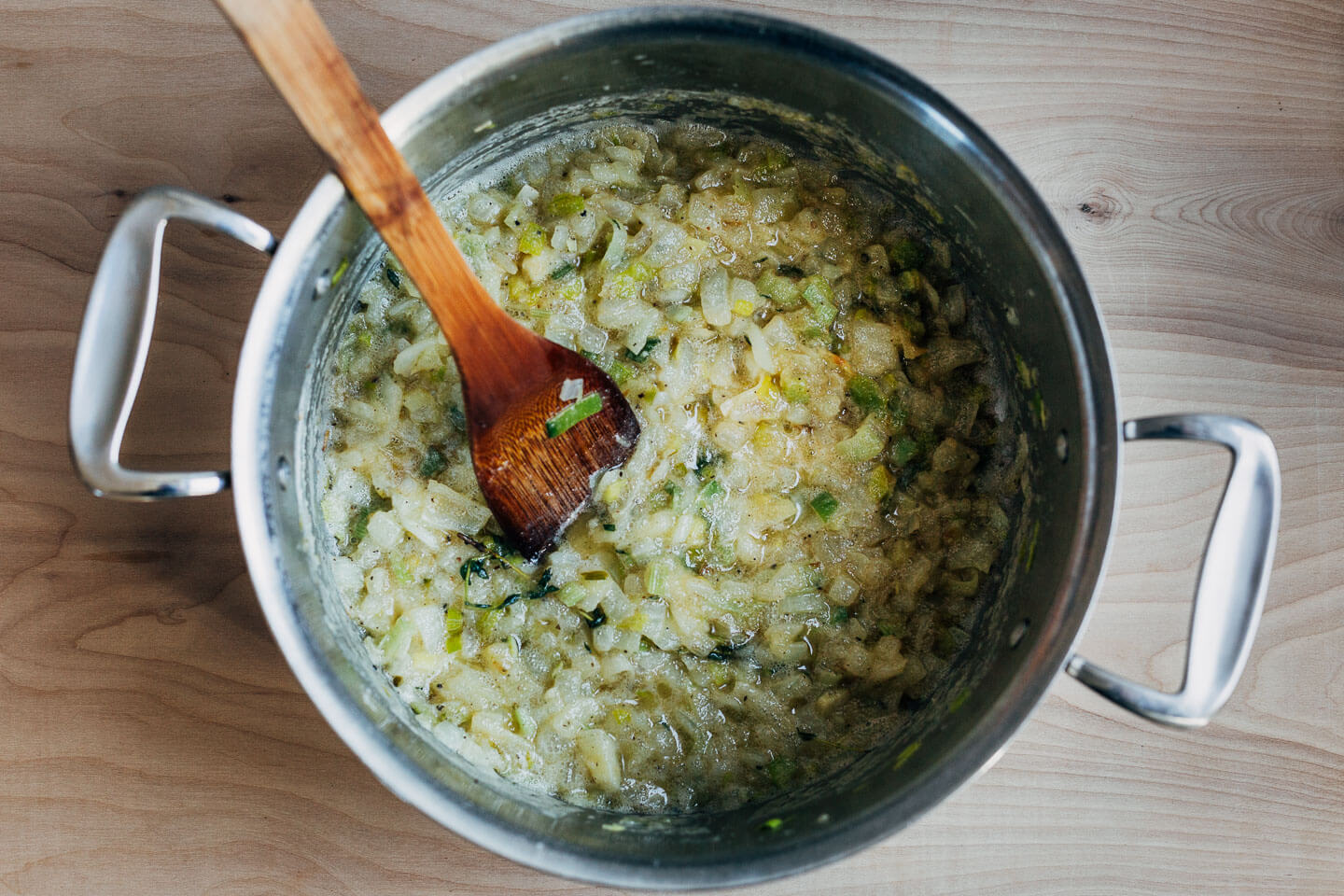 A pot with butter-sauteed onlions and leeks.
