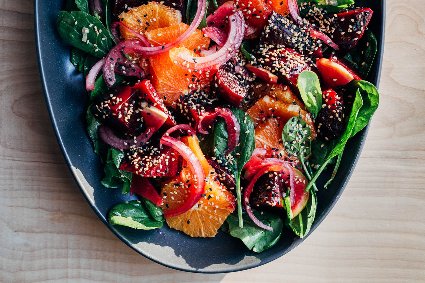 A platter of beet and citrus salad in bright sunlight